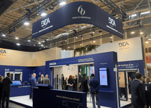 Stand de BEA sensors en almemani BAU 2025 enero, personas en el stand , viendo sensore laser color azul oscuro y blanco con pantallas led y puertas automáticas
